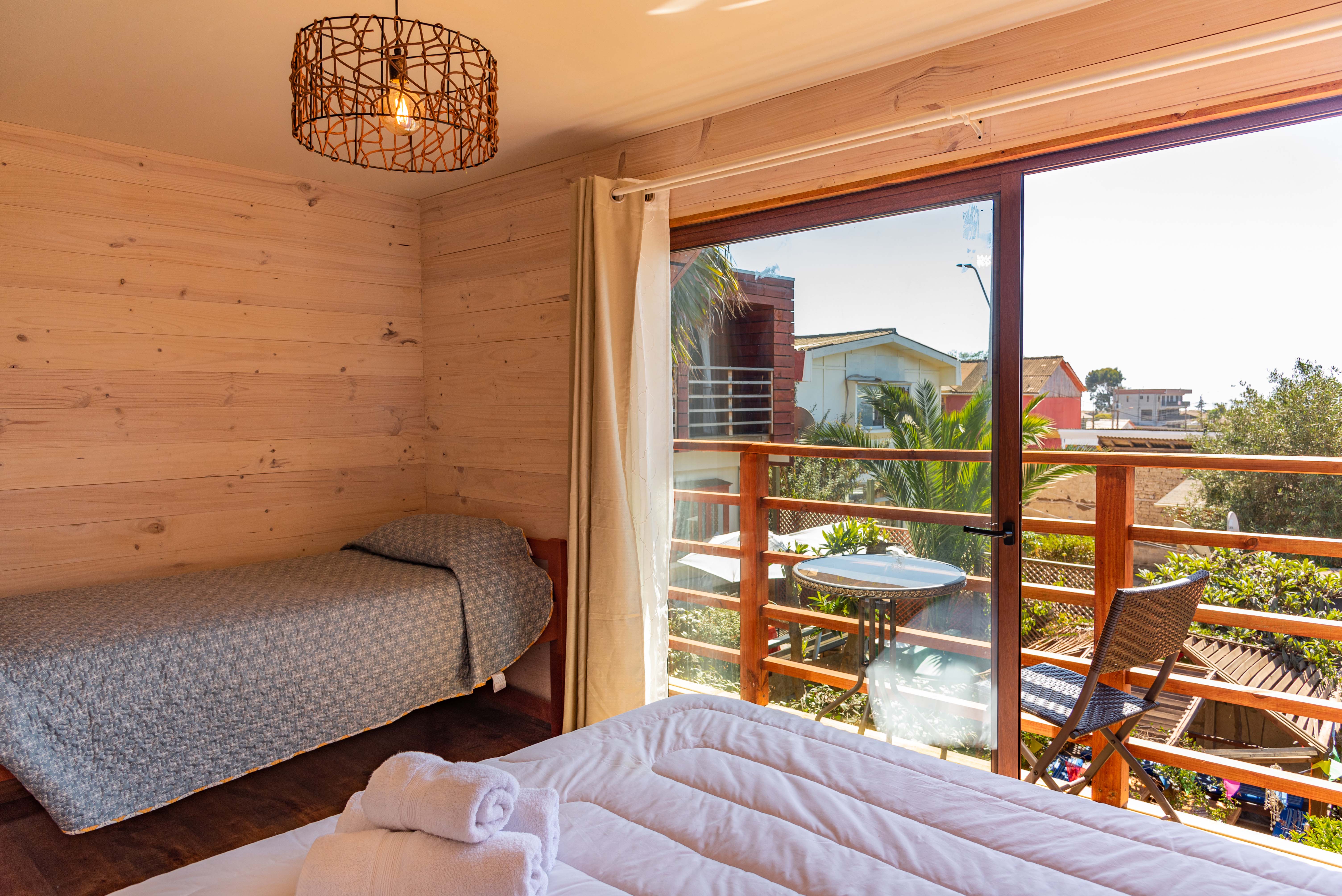 Habitación Triple, con una cama Matrimonial y una cama de una plaza, baño privado, balcón privado con vista al mar y tv cable..