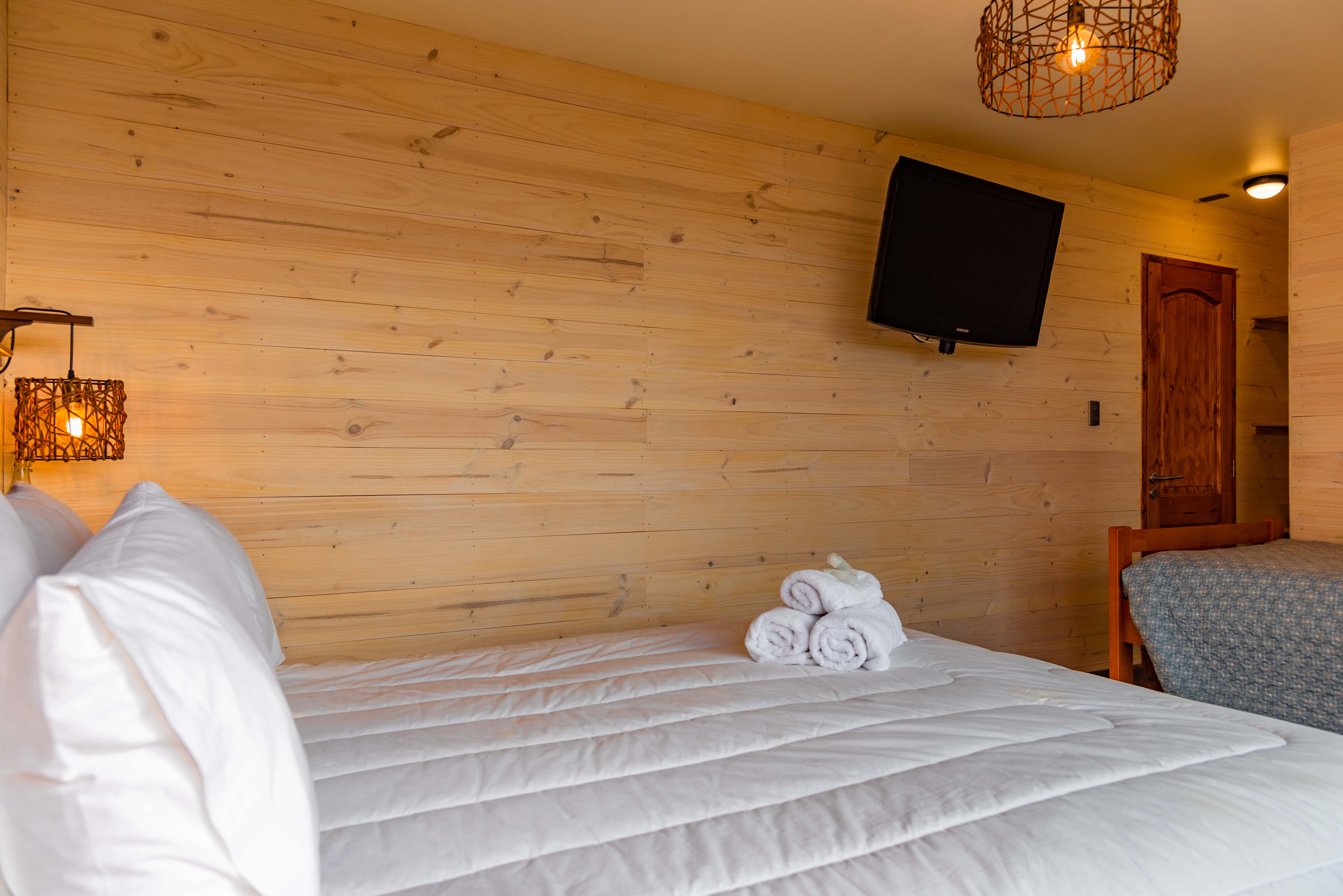 Habitación Triple, con una cama Matrimonial y una cama de una plaza, baño privado, balcón privado con vista al mar y tv cable..